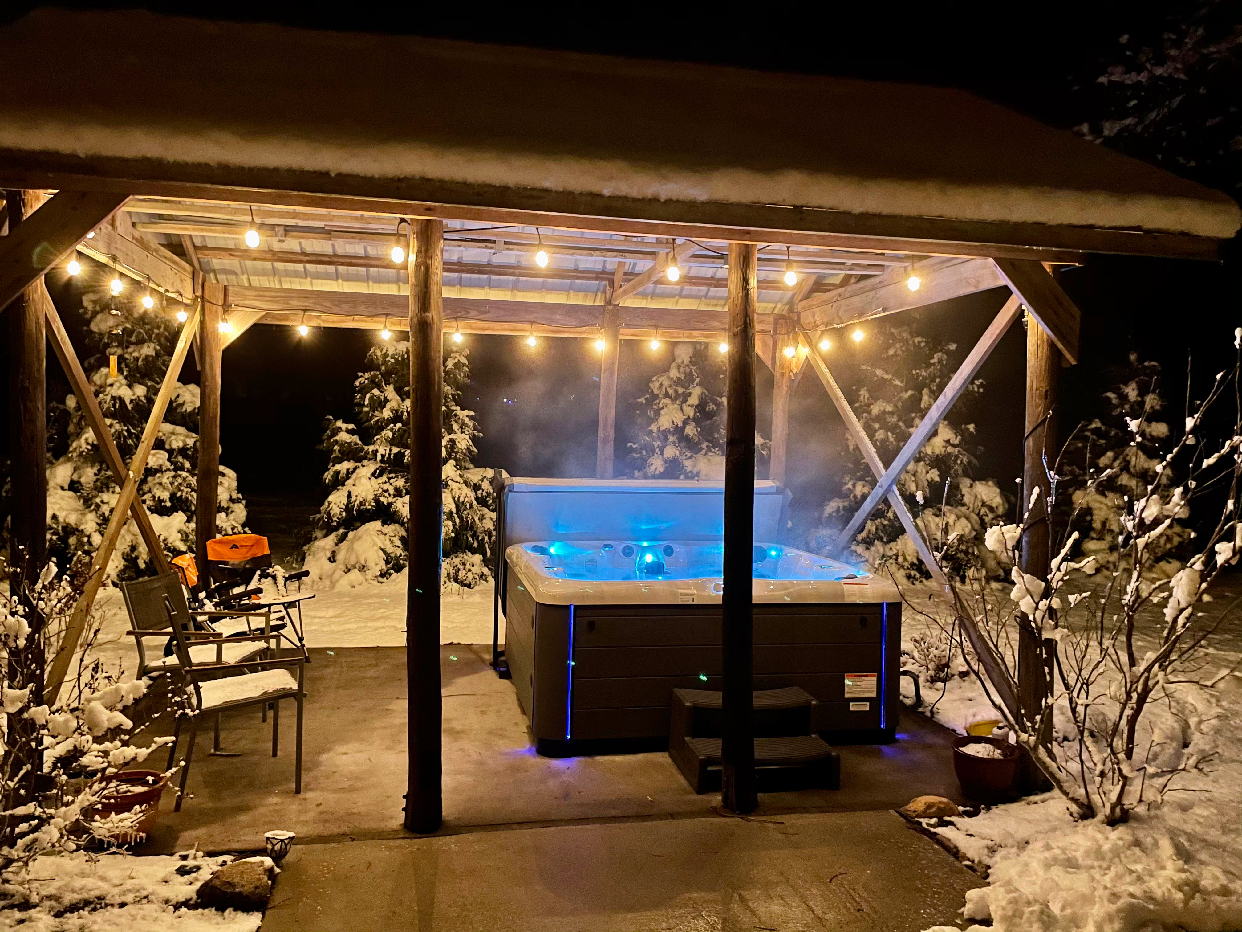 Legend Series spa under a snowy pavilion at night