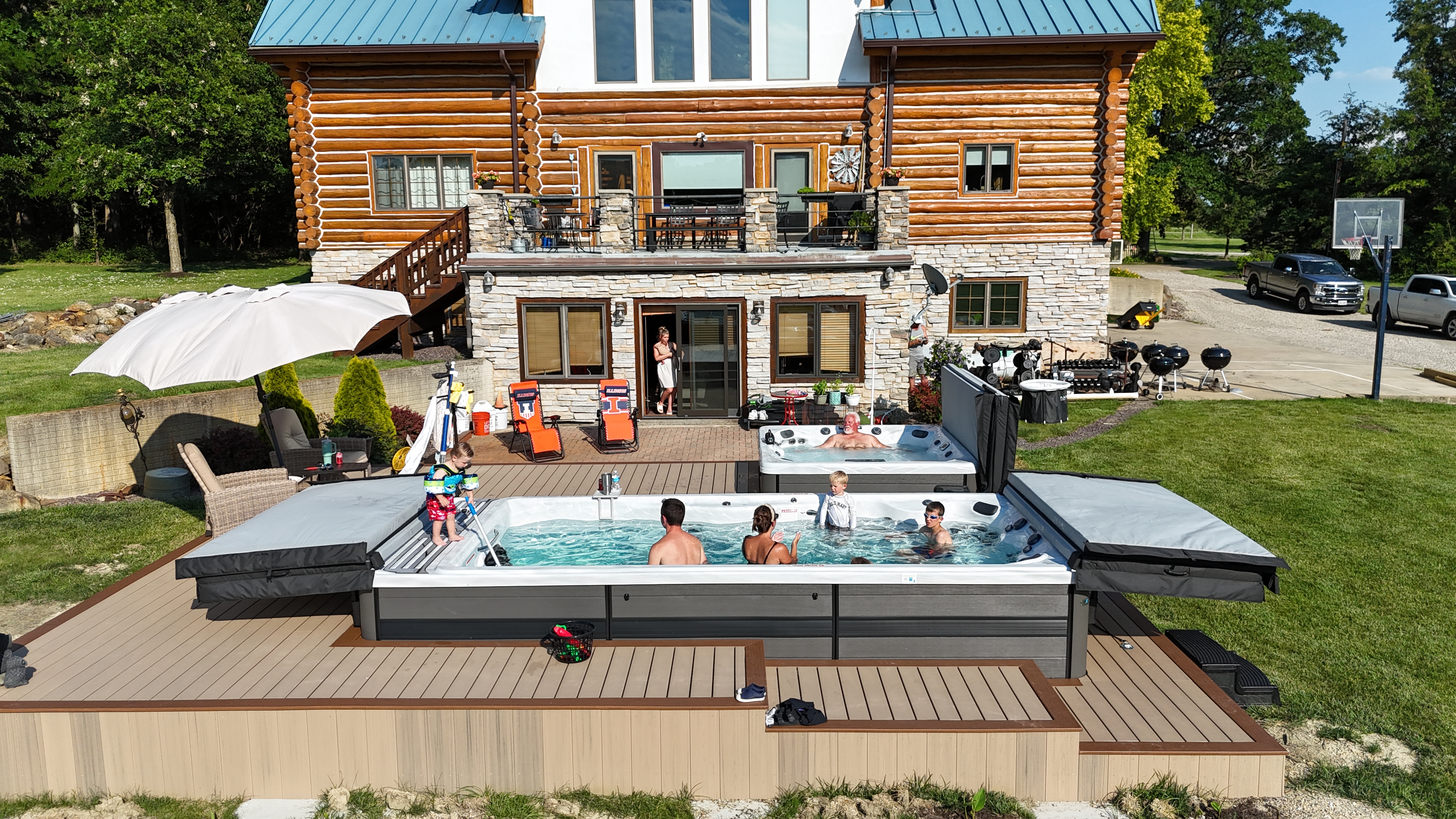 Mahomet family enjoying a Twilight hot tub and swim spa backyard oasis